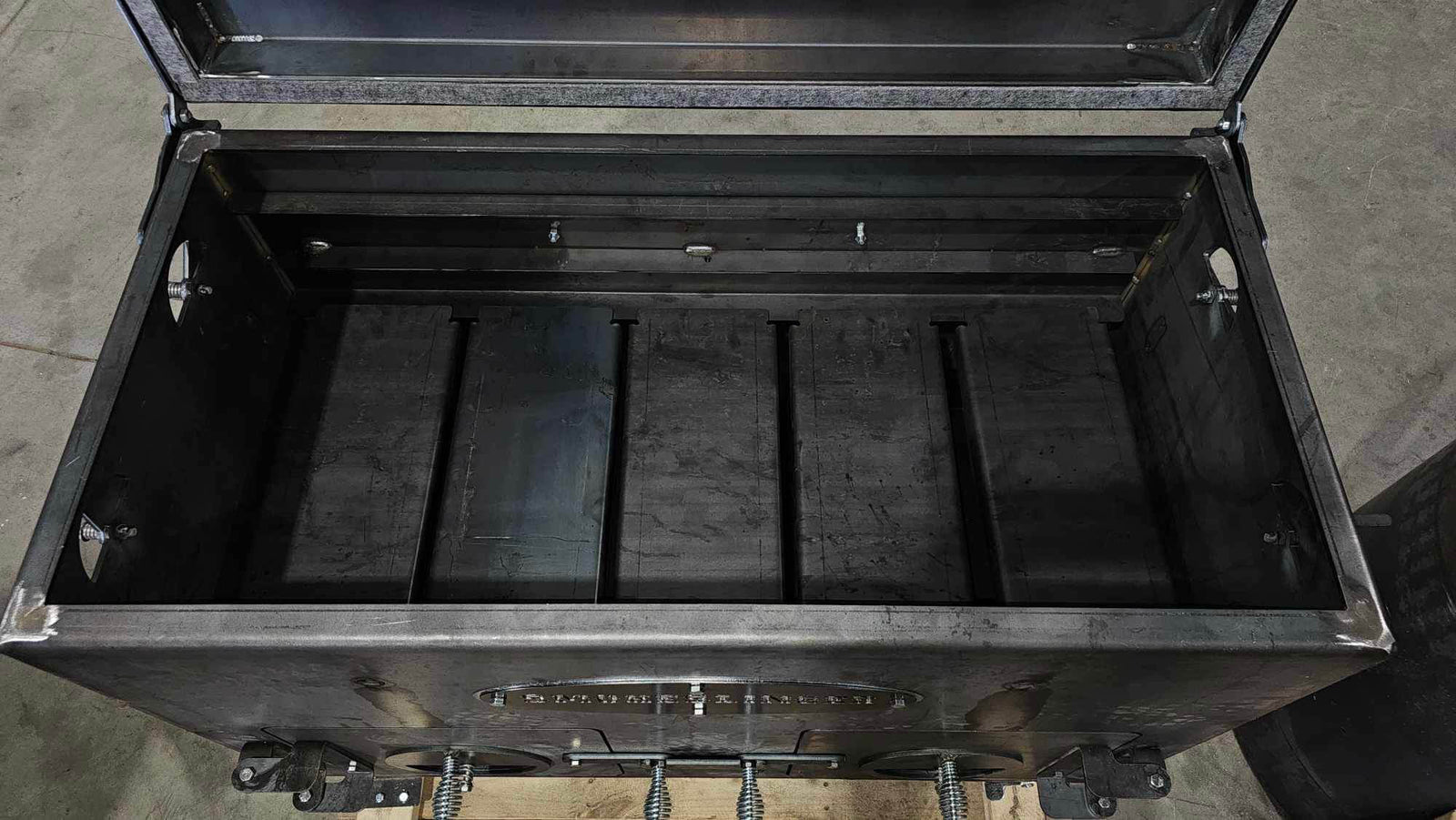 image of the top view of a smokeslinger smoker with the lid open showing the cooking grate removed and the tuning plates exposed