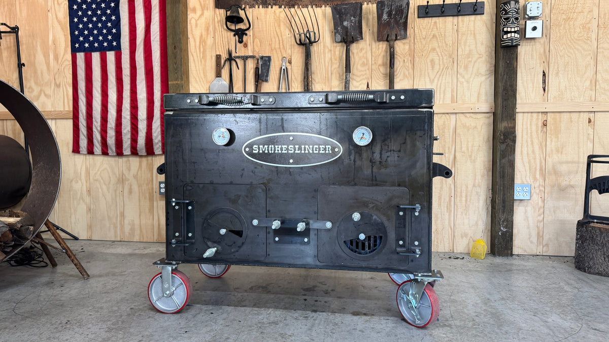 Full Size Smokeslinger direct heat smoker, front view, on red casters in the Smokeslinger shop