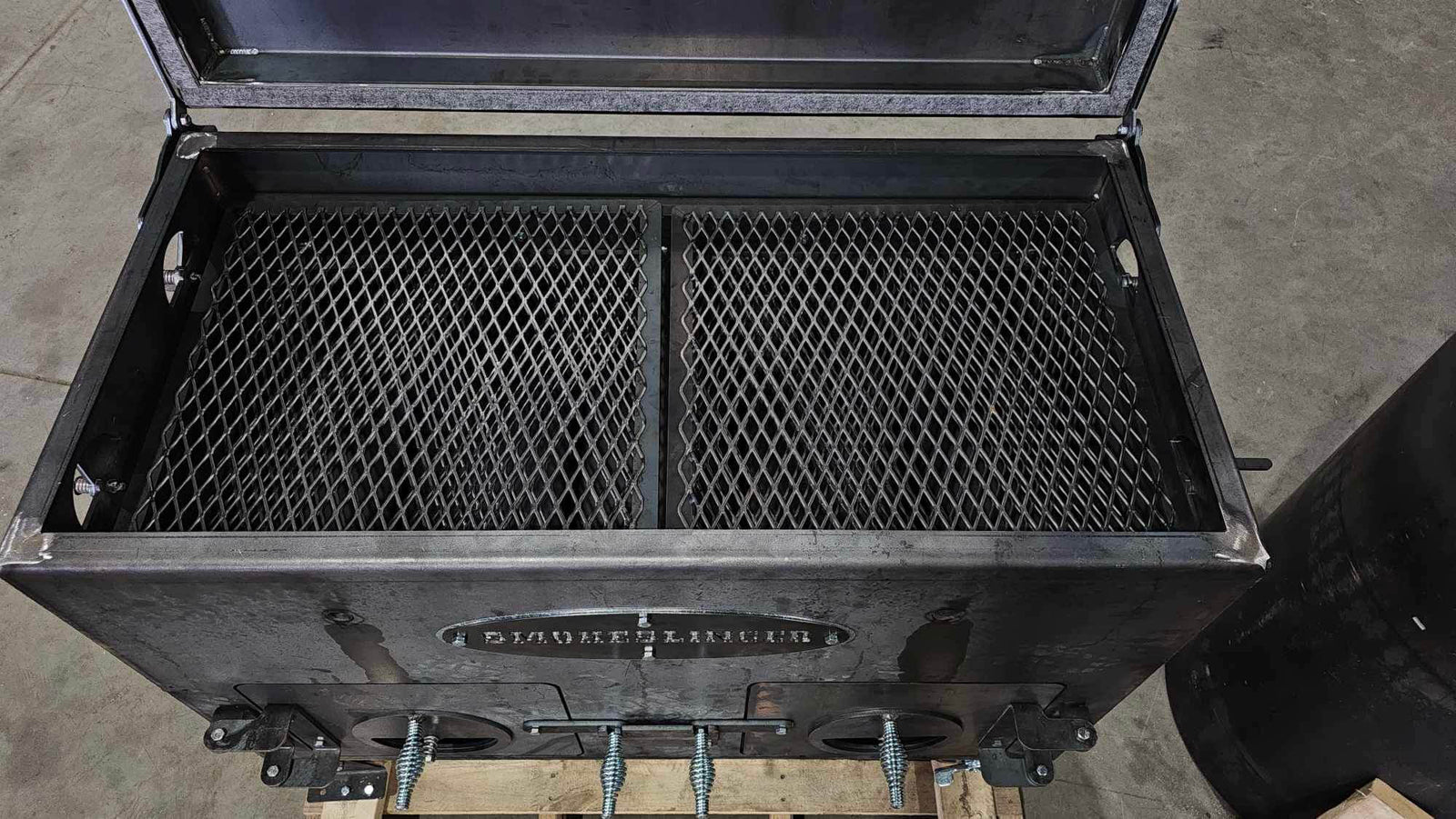 image of the top view of a smokeslinger smoker with the lid open showing the cooking grate mesh