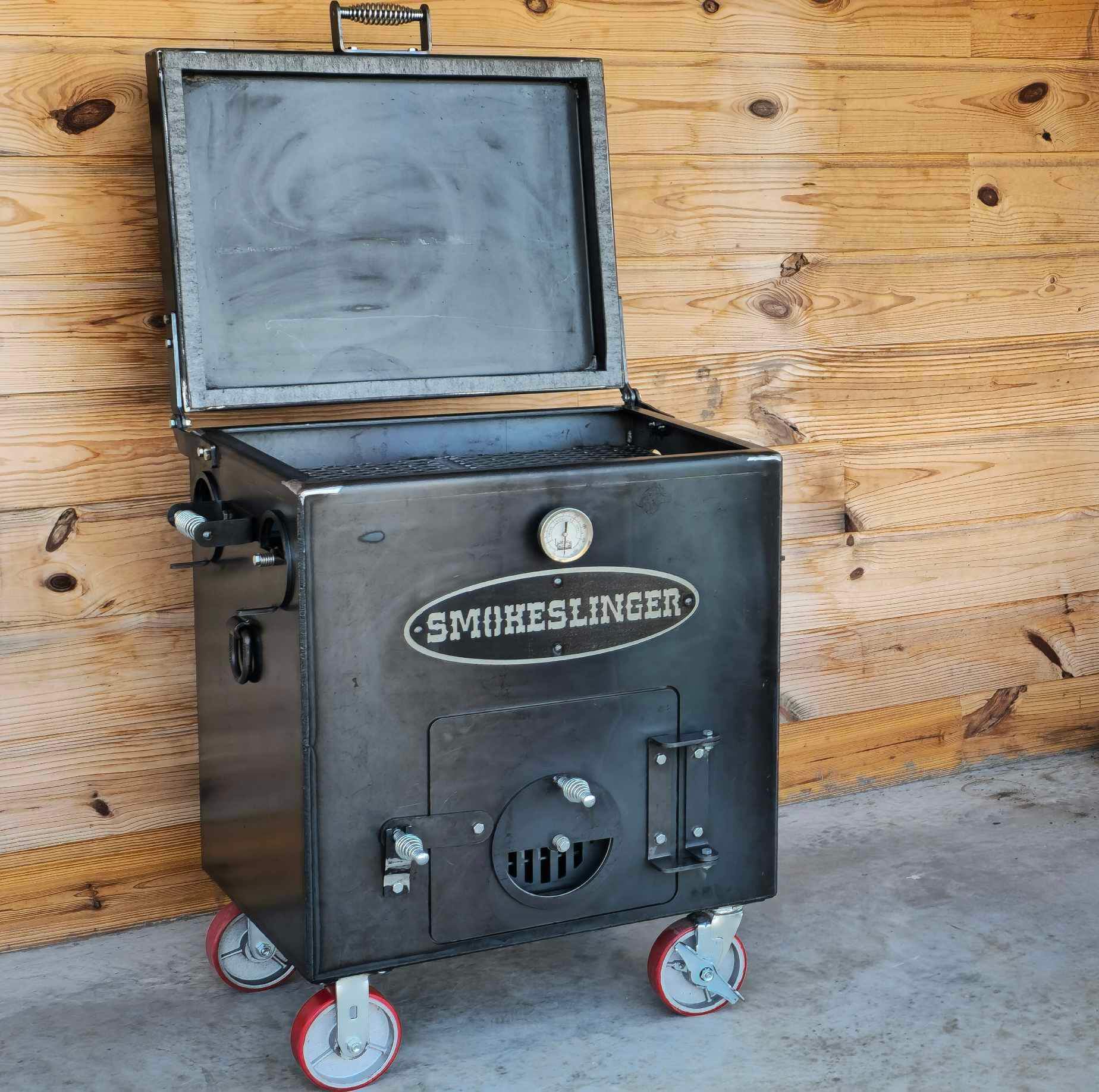 image of the top view of a mini smokeslinger smoker with the lid open with a natural stained wood wall and sitting on concrete
