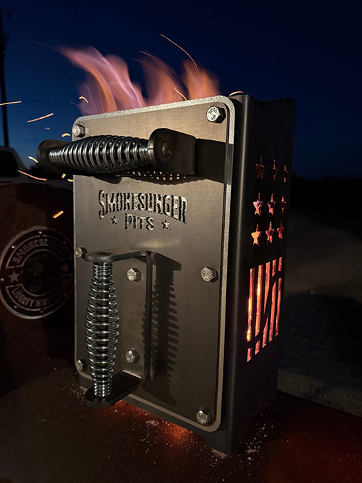 XL charcoal chimney lit at night with flames coming out the top