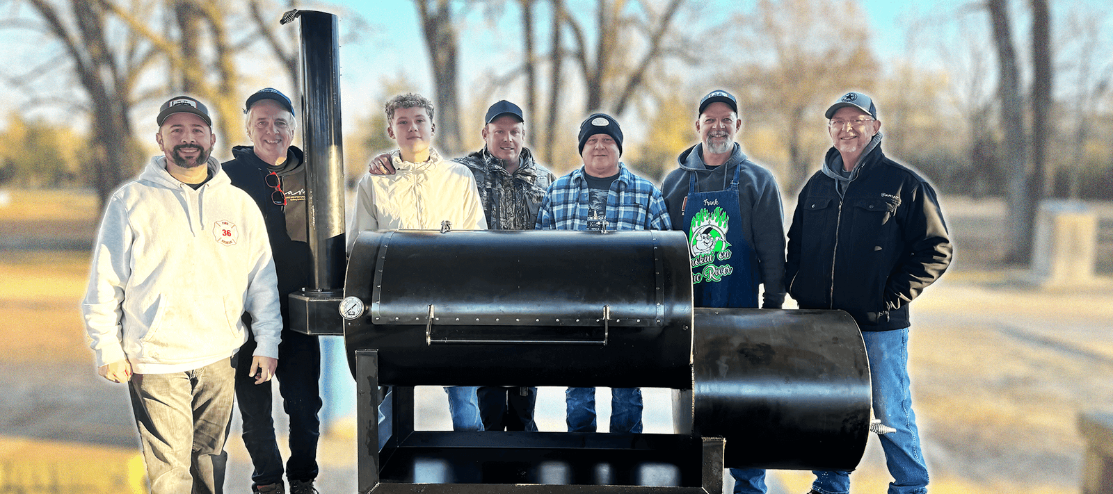 group of guys standing around the Liberty94 offset smoker at one of the Smokeslinger Meat Ups
