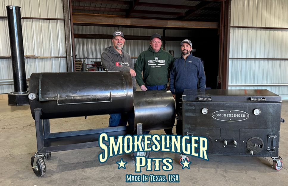 Liberty94 offset smoker on the left and the full size smokeslinger on the right inside the shop with frank, dustin, and dave standing behind them